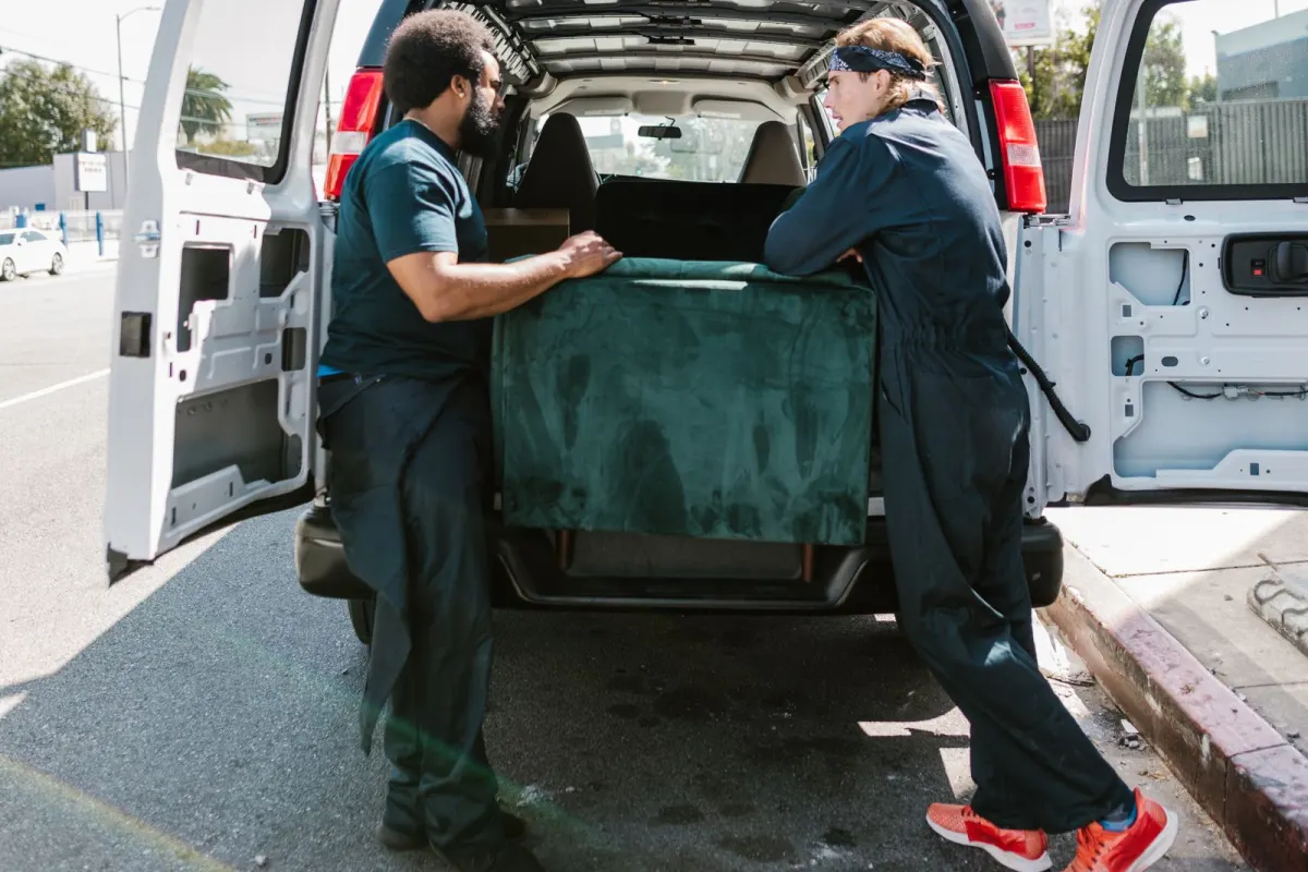 Movers loading furniture into a van on moving day