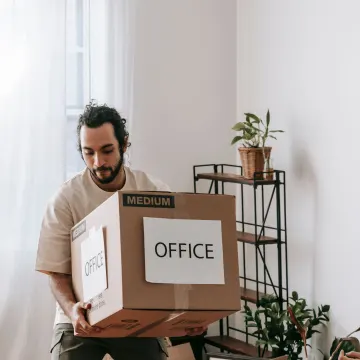 Man carrying a carton labelled office during an office move