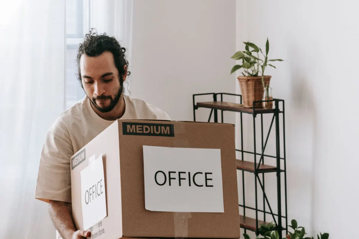 Man carrying a carton labelled office during an office move